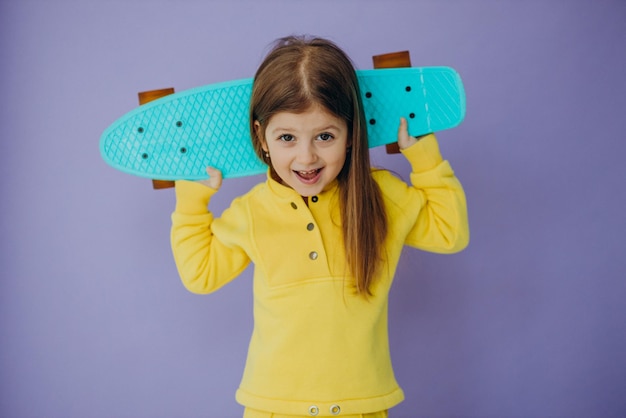 Cute little girl with skateboard in studio