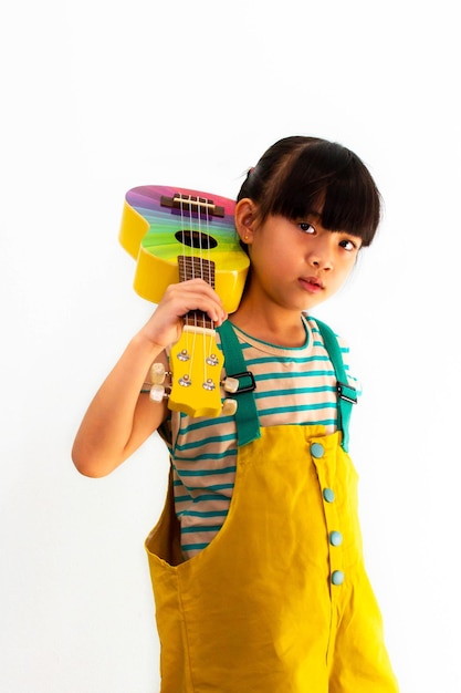 Cute little girl with ukulele on white background