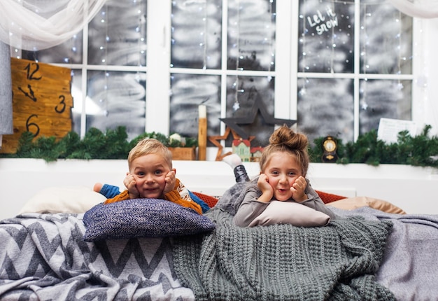 Cute little kids boy and girl at home waiting for Santa Claus