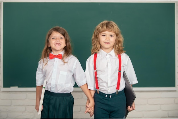 Cute little school kids friends studying together in classroom friendship in school classmate concep