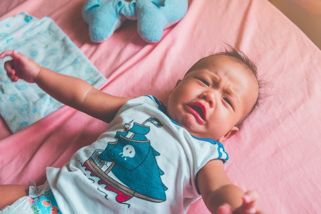 Cute little six month old asian baby boy crying