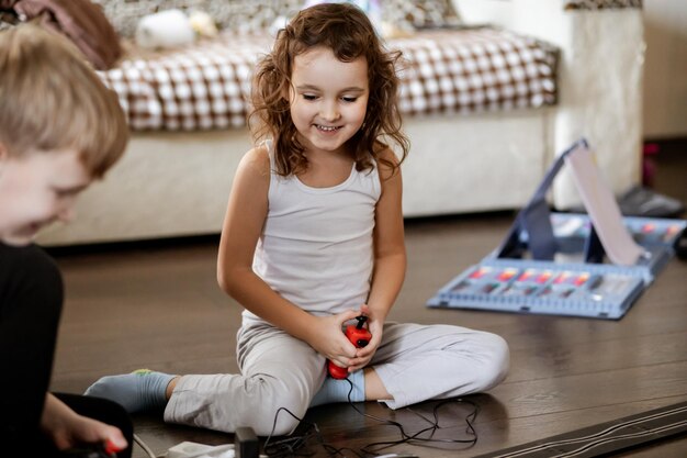 Cute little teen boy and girl playing with a railroad train toy at home