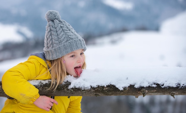 Cute little winter girl eating snow outdoor excited christmas kids holiday kids cold and flu concept