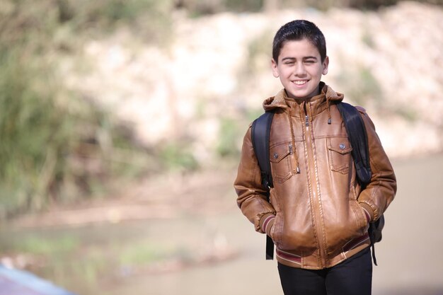 A cute little young boy walking in the outdoor forest park