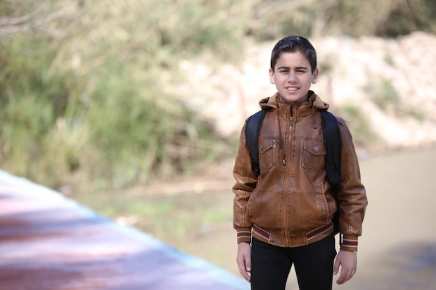 A cute little young boy walking in the outdoor forest park