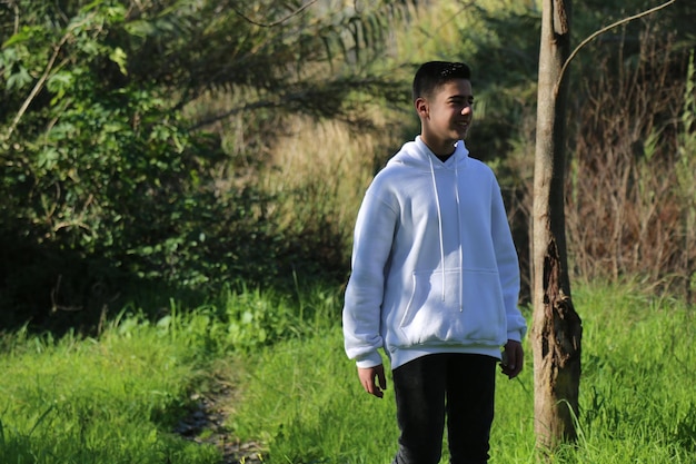 A cute little young boy walking in the outdoor forest park