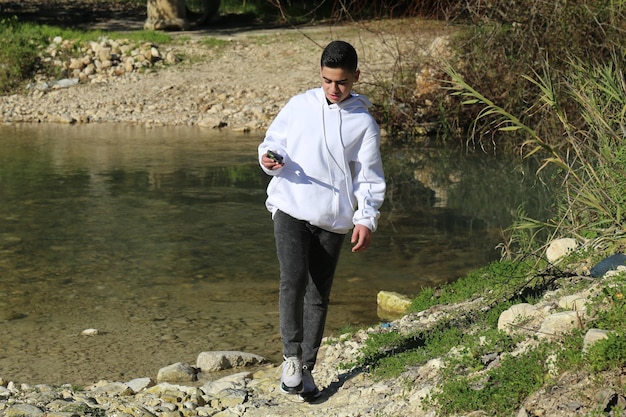 A cute little young boy walking in the outdoor forest park