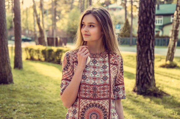 Cute long haired brunette female in an autumn park.