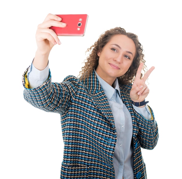 Of a cute lovely woman taking selfie and showing peace sign with fingers over white background