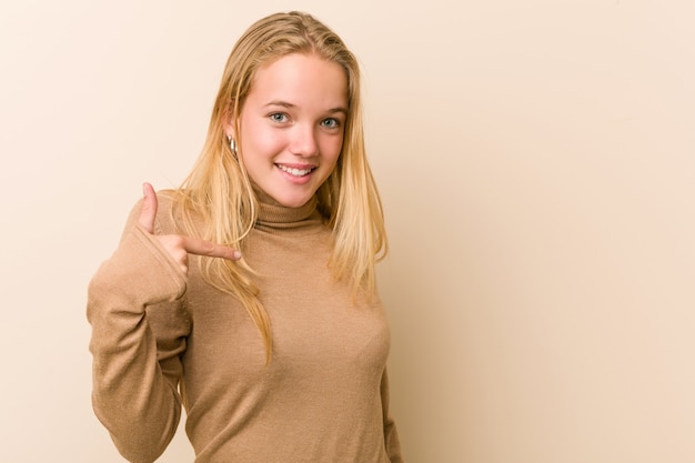 Cute and natural teenager woman person pointing by hand to a shirt copy space, proud and confident