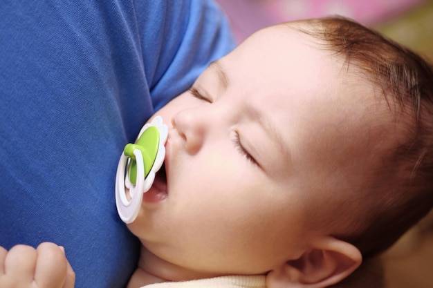 Cute newborn baby sleeping in father arms close up A loving father carries her newborn baby at home portrait of a happy mother holding a sleeping baby