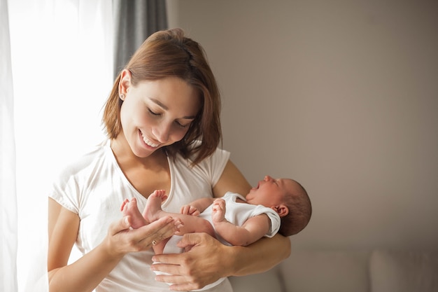 Cute newborn baby sleeping in mother's arms. Motherhood.