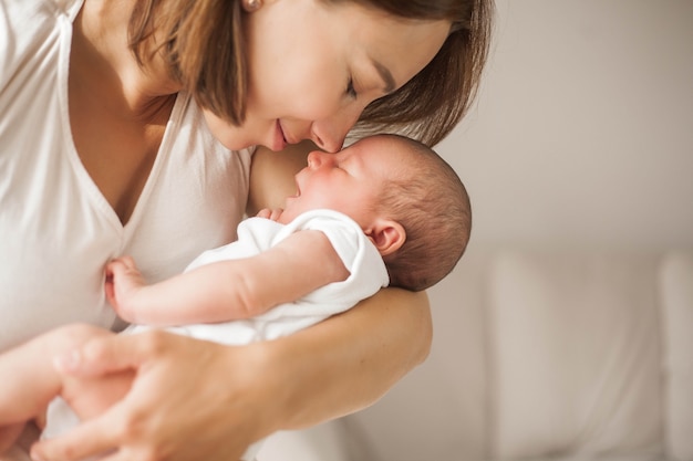 Cute newborn baby sleeping in mother's arms. Motherhood.