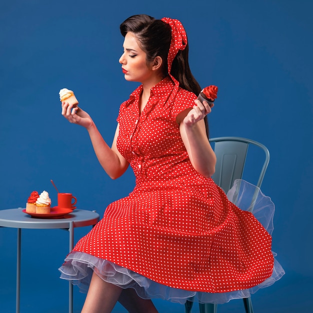 Cute pinup girl posing in a blue studio