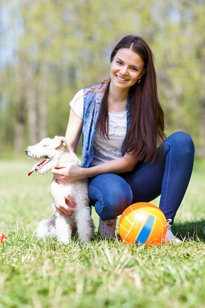 Cute portrait of a woman with her dog at the park