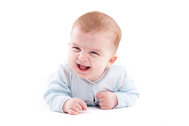 cute pretty little boy in blue shirt lies on belly