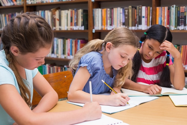 Cute pupils drawing in library