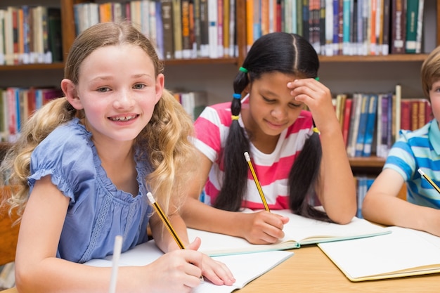 Cute pupils drawing in library