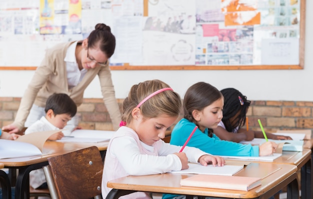 Cute pupils drawing at their desks