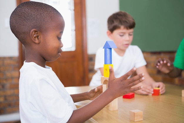 Cute pupils playing with building blocks 