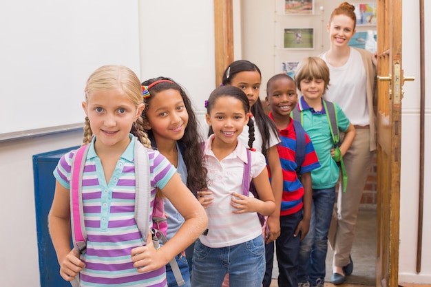 Cute pupils smiling at camera in classroom 