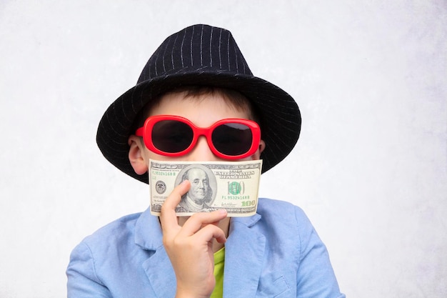 A cute rich boy with glasses is holding dollars