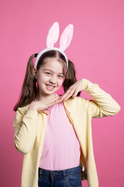 Photo cute schoolgirl with pigtails and bunny ears fooling around in the studio