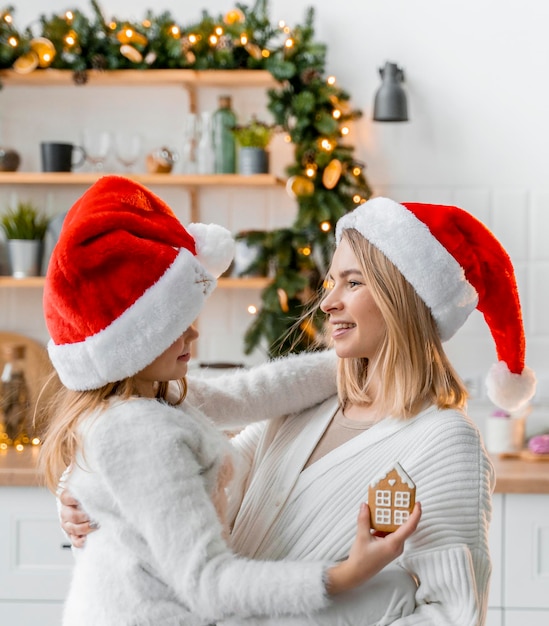 Cute sisters have fun in the kitchen enjoying christmas time with christmas cookie