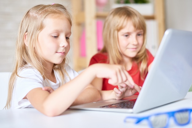 Cute Sisters Using Laptop