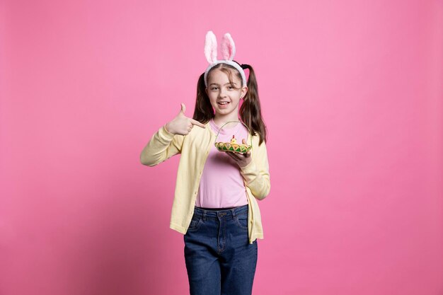 Cute small girl grabs an arrangement of eggs and a chick