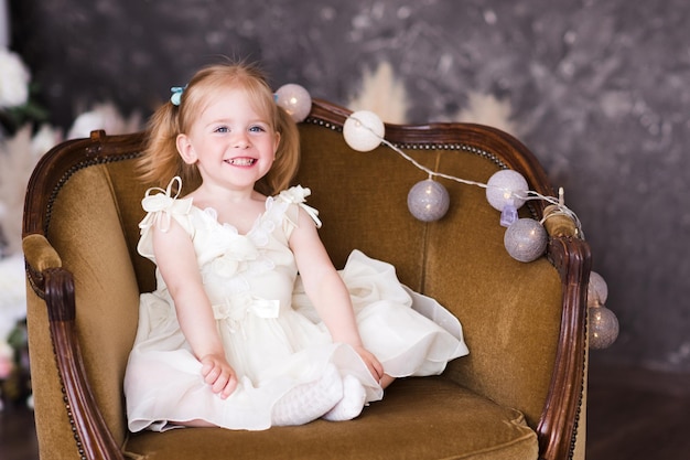 Cute smiling girl sitting on arm chair