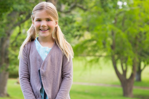 Cute smiling girl standing at the park