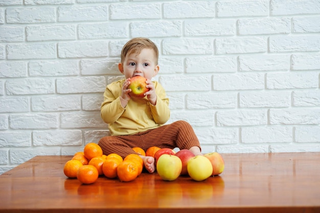 Cute smiling kid eating one fresh juicy red apple Healthy fruits for young children