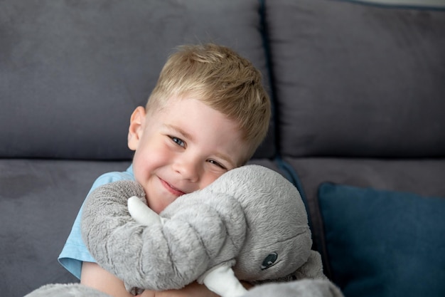 A cute smiling little boy hugs a stuffed toy, he happy. The concept of childhood.