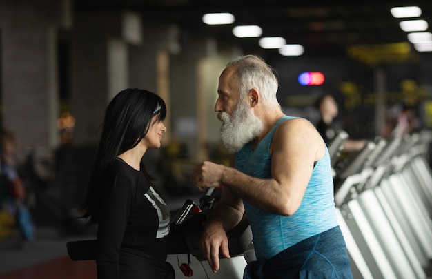 Cute smiling senior couple exercising in gym.