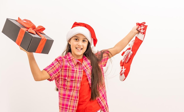 Cute smiling toddler girl in a red dress checking her Christmas stocking