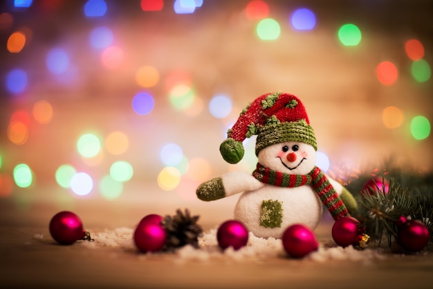 Cute snowman in red and green hat and scarf and Christmas balls