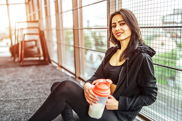 Cute sporty girl sitting in the gym