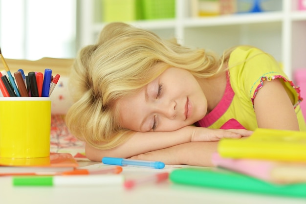 Cute  student girl sleeping near books at class