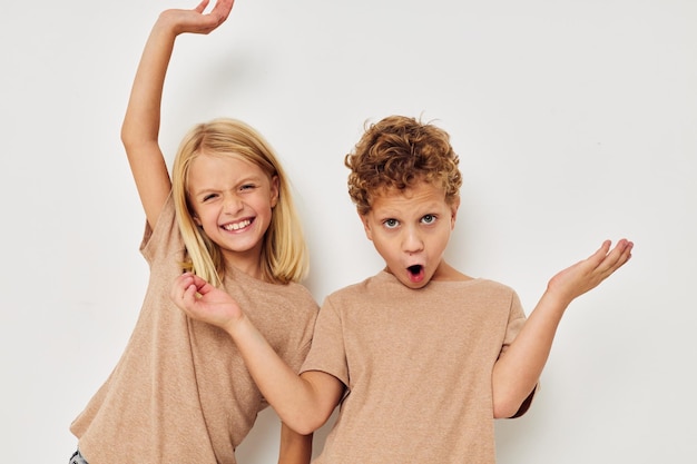 Cute stylish children in beige tshirts posing for fun childhood unaltered