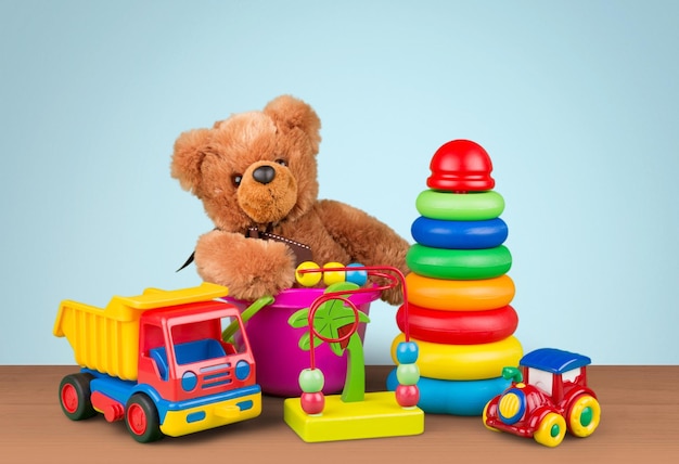 Cute teddy bear and bright toys on wooden table