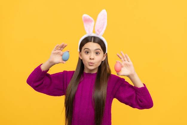 Cute teen child in bunny ears holding colorful easter eggs easter egg