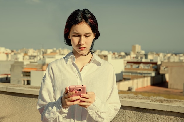 Cute teenage girl communicates on mobile phone smartphone