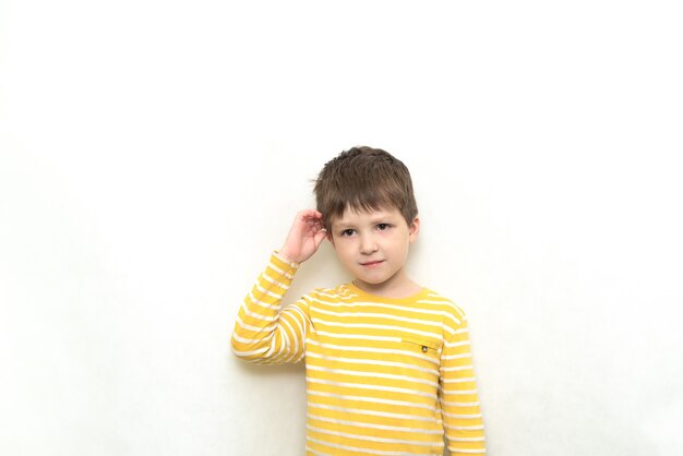 Cute toddler boy caucasian in striped shirt with funny expression