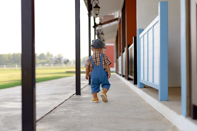 Cute toddler boy in jeans walking along the way