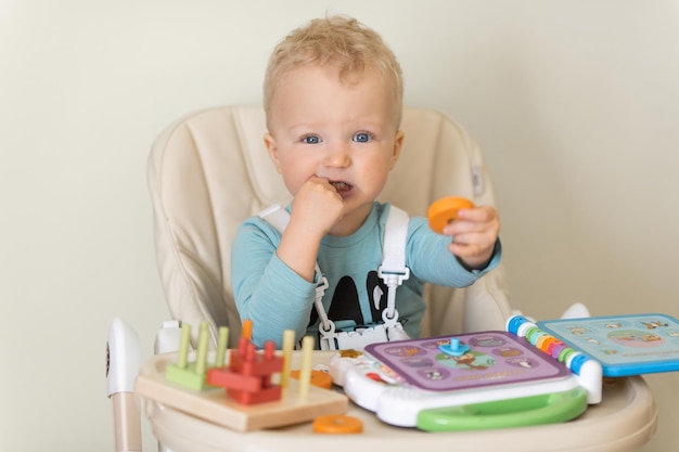 Cute toddler child eating piece of cake and drinking juice at home