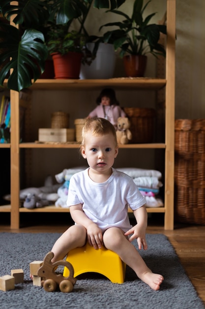 Cute toddler girl, potty training, playing with his toys on potty