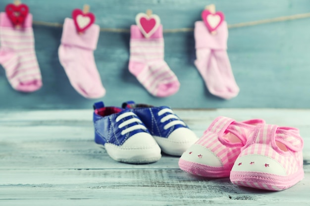 Cute toddler shoes and socks on wooden background