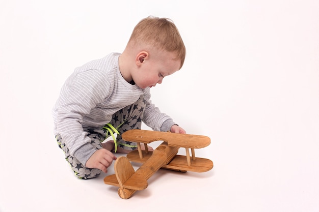 Cute toddler with dermatitis with plane on white backgorund