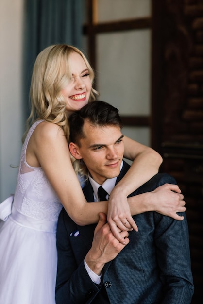 Cute wedding couple in the interior of a classic studio decorated They kiss and hug each other